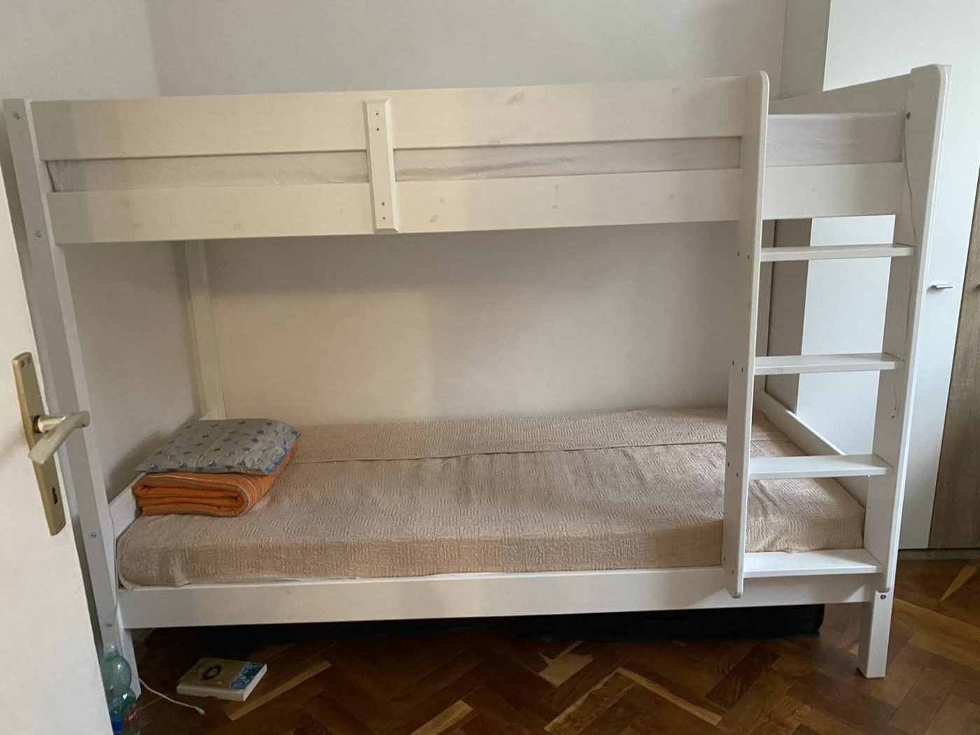 Montaža belog kreveta na sprat sa merdevinama